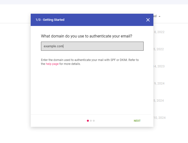 Screenshot of a modal popup in Google Postmaster Tools with a "Getting Started" dialog box asking for a domain to authenticate email. A text field displays "example.com". There is a note below the field about SPF or DKIM, and "NEXT" button at the bottom right. Background shows a blurred list.
